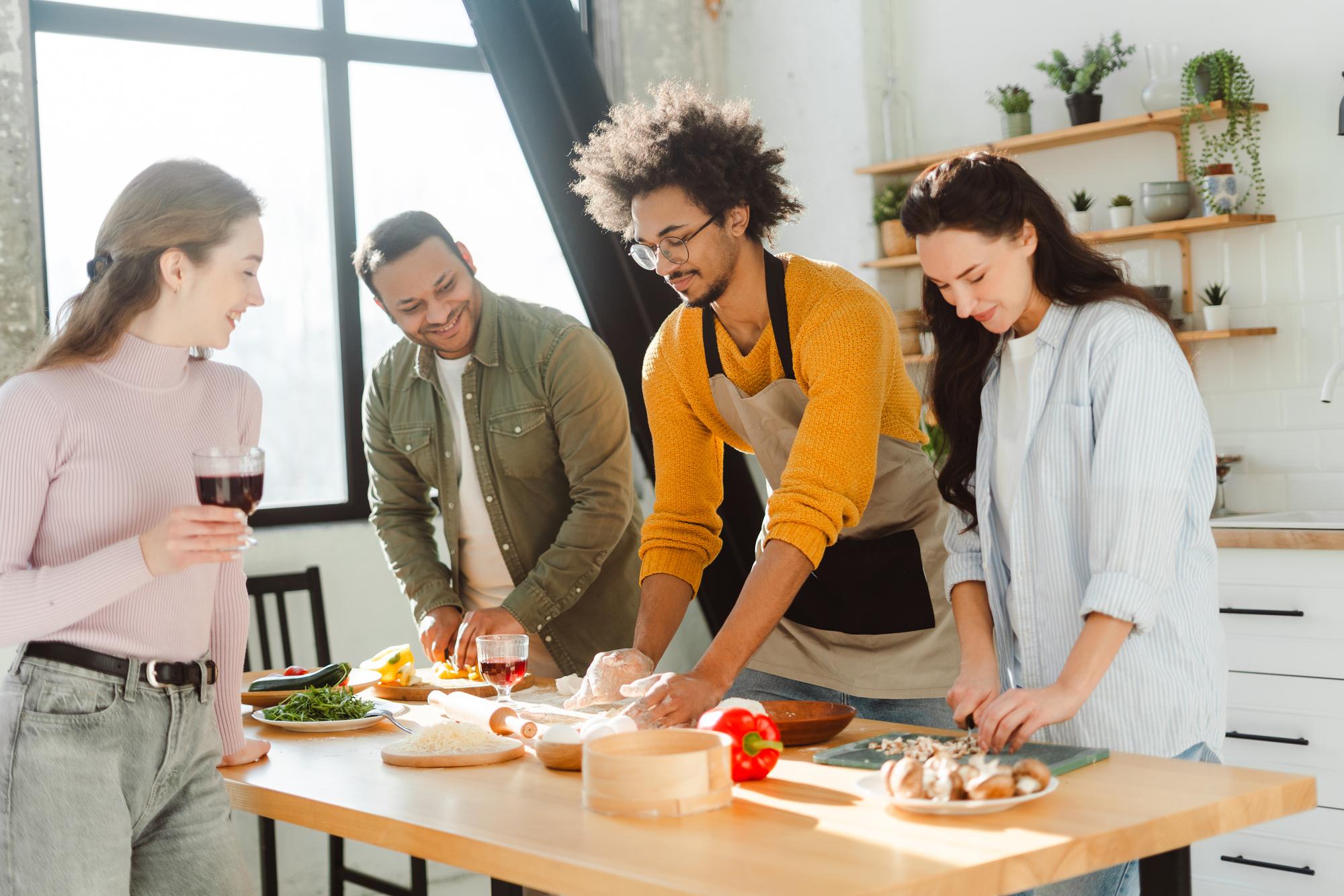 Students cooking together around a workbench